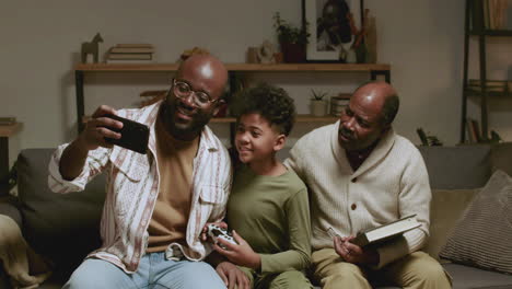hombres negros y un niño en la sala divirtiéndose por la noche.