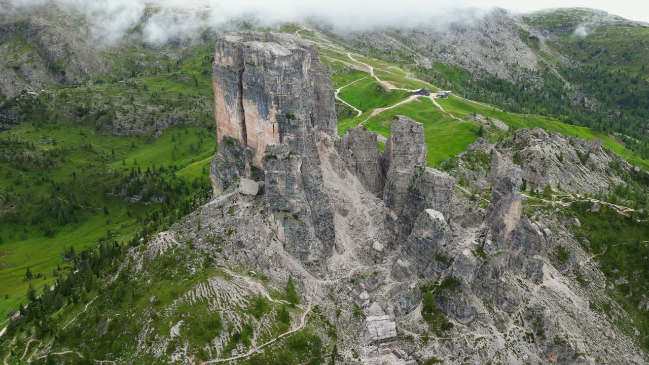 Sweeping aerial panorama revealing rugged Cinque Torri mountain group nestled within verdant Dolomites landscape of northern Italy