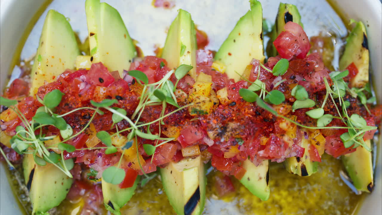 Close up of a woman eating avocado with cut up tomatoes
