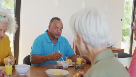 happy senior diverse people having breakfast at retirement home