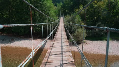 picturesque suspension bridge over a calm river in a lush forest