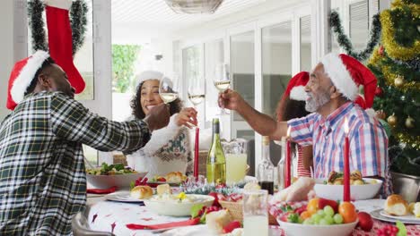 Feliz-Familia-Multigeneración-Afroamericana-Con-Gorros-De-Papá-Noel-Y-Celebrando-La-Comida-Navideña