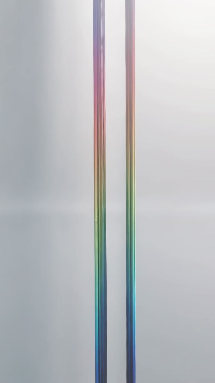 Vertical video: Playing color columns splitting and brightening on gray backdrop with midband grain