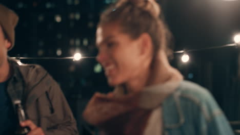 young group of multiracial friends having fun dancing playfully together enjoying rooftop party at night laughing celebrating friendship