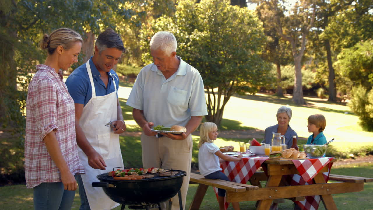 Uomo felice che fa barbecue per la sua famiglia