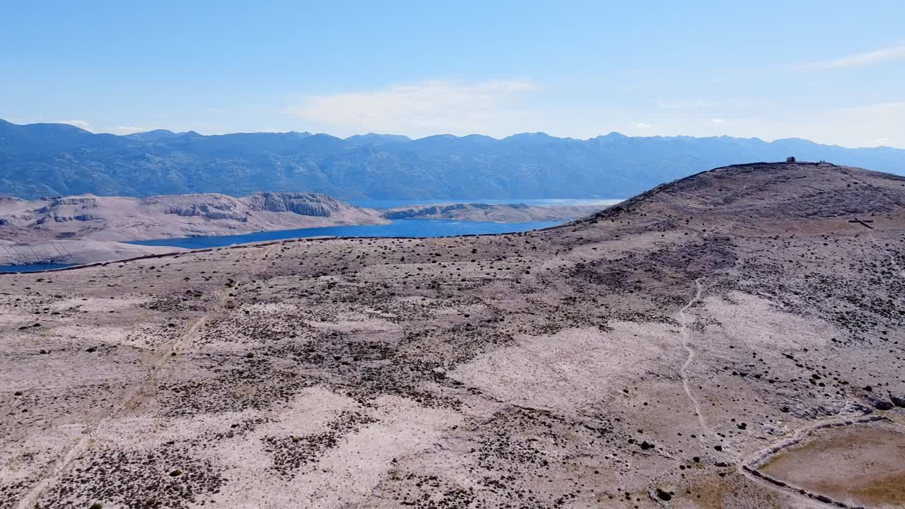 vista aérea que revela el mar y la tierra detrás de la cima de la montaña de la isla