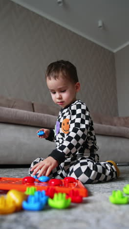 child play in kindergarten. small boy playing with colorful toys. vertical video.