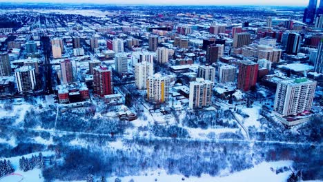 aerial hold over downtown edmonton victoria park edge on a winter day birds eye view over the high rises of apartments and condominiums with snow covered trees realty properties for rent or for sale