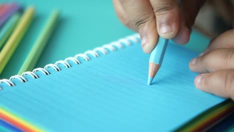child coloring in a notebook