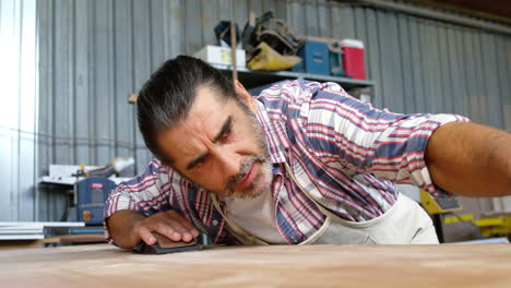 serious carpenter checking his work