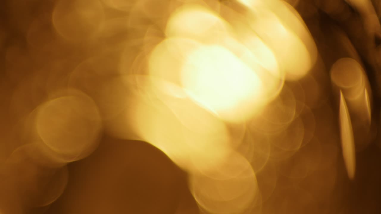 Luci bokeh dorate astratte scintillanti su sfondo scuro