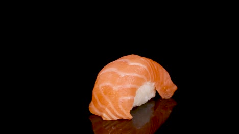 salmon nigiri sushi rotates smoothly on a glossy black surface, illuminated by soft studio lighting, highlighting texture and freshness in a seamless loop