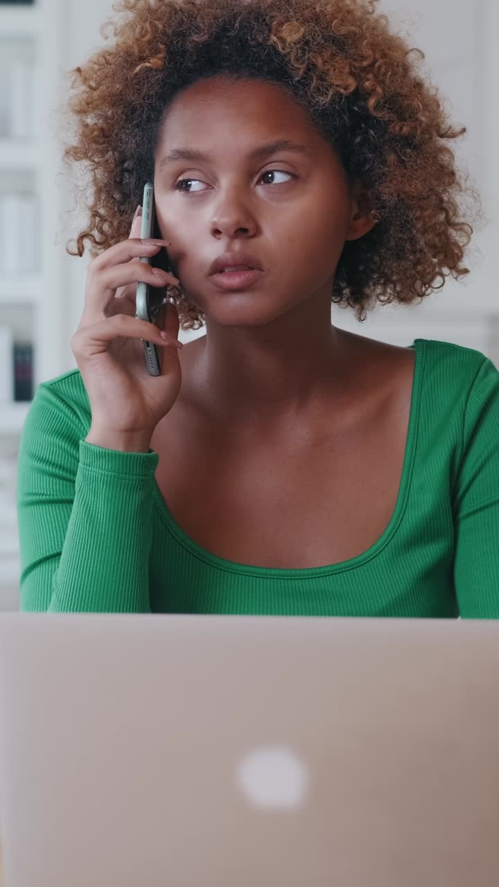 Woman on a Phone Call While Working on Laptop