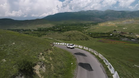 Coche-Blanco-Solitario-Conduciendo-A-Lo-Largo-De-La-Carretera-De-Montaña-Del-Acantilado-Con-Barrera-De-Hormigón-Fuera-Del-Distrito-De-Aspindza-En-Georgia