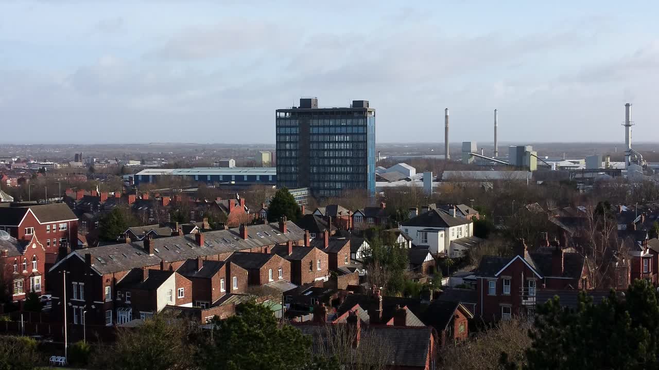 vista aérea descendente sobre los árboles del parque a la vivienda del paisaje industrial de la ciudad y el rascacielos blue pilkingtons, merseyside, inglaterra