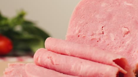 ham italian mordatella, man slices of traditional italian antipasti mortadella sausage on a wooden cutting board, close up macro of chicken or turkey jamon, fat breakfast dish.