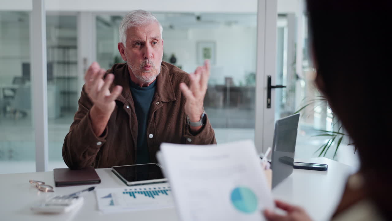 Senior Businessman Listening Attentively During an Office Meeting