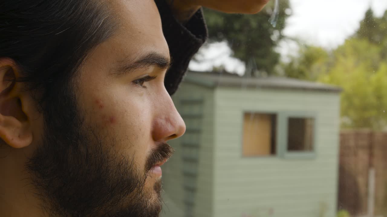 hombre mirando por la ventana con anhelo en cuarentena de cerca