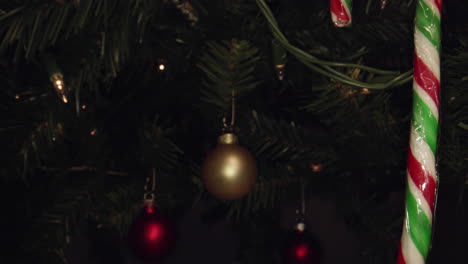 Dolly-Vorbei-An-Einer-Zuckerstange-Zu-Einem-Goldenen-Ornament,-Das-An-Einem-Weihnachtsbaum-Hängt