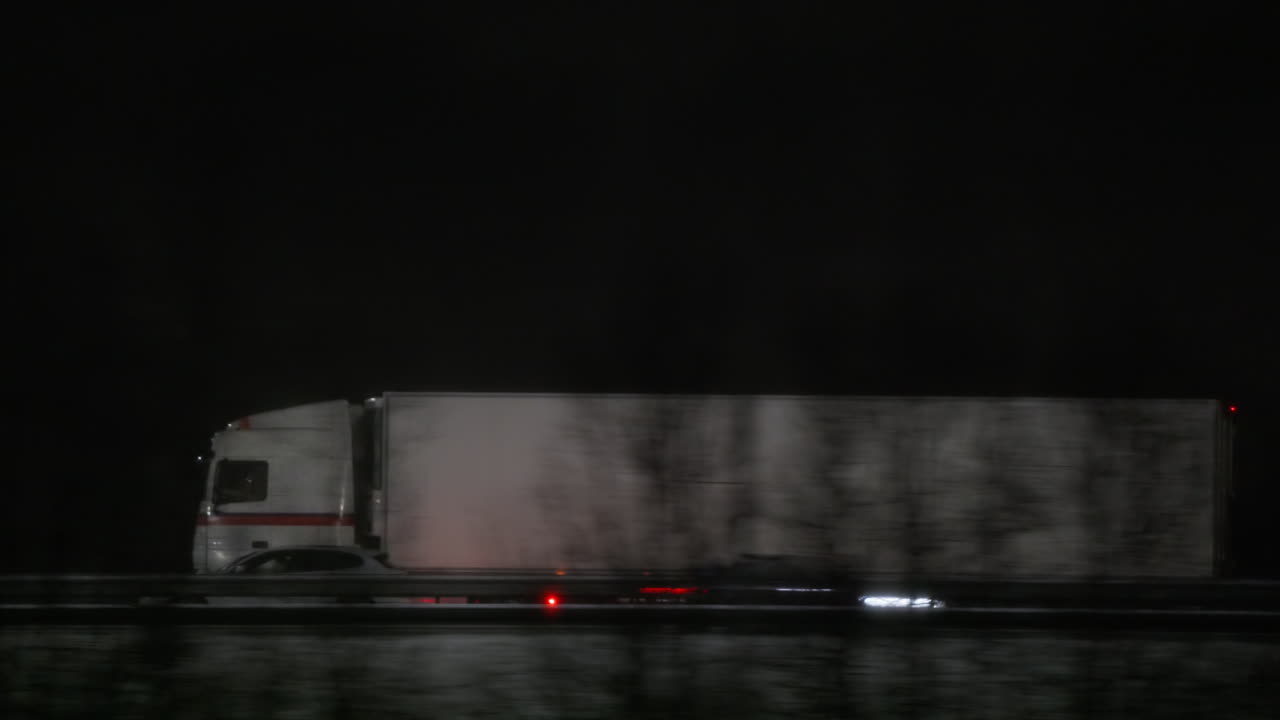 Semirimorchio bianco in viaggio su un'autostrada nebbiosa di notte