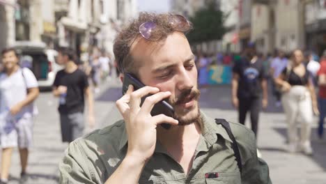 Hablando-Por-Teléfono-En-La-Calle-Llena-De-Gente.