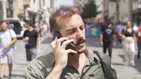hablando por teléfono en la calle llena de gente.