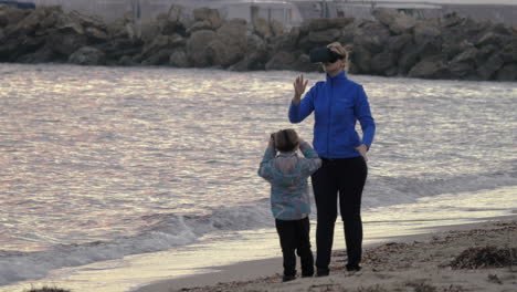 mother and son having fun with vr glasses on the shore