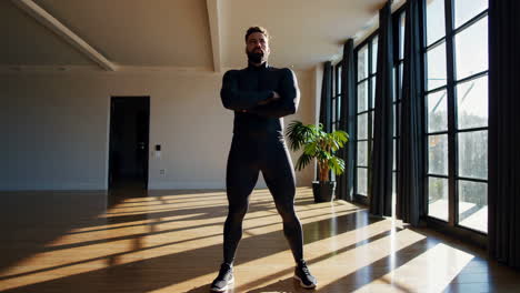 man in fitness apparel posing in a sunny home gym