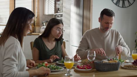 caucasian family of three sharing breakfast food together