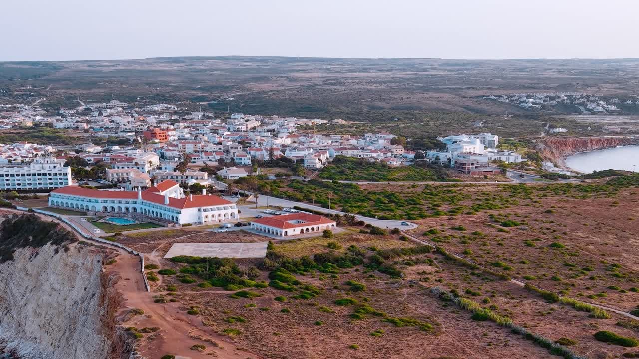 Tramonto su un villaggio costiero in Portogallo con edifici e colline