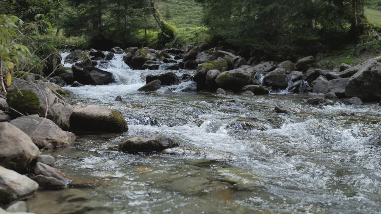 A calm mountain stream with rocks and greenery in Schladming, evoking peace and nature