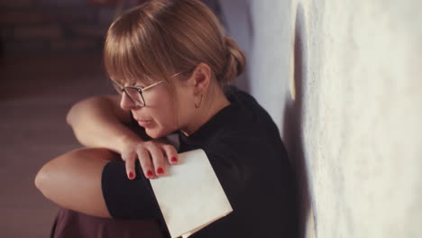 woman sitting by a wall