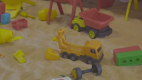 toy trucks and other toys in a sandbox