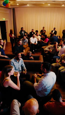 people socializing and enjoying drinks at a lively indoor event