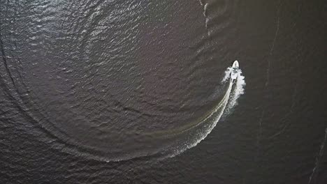 drone shot of a speeding boat in an urban lake