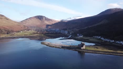 lochranza castle descending pan revealing snowy mountains aerial footage, isle of arran