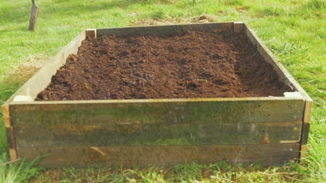 Watering-raised-garden-bed-sown-seeds-in-compost-soil