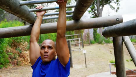 entrenadora aplaudiendo mientras está en forma hombre escalando barras de mono 4k
