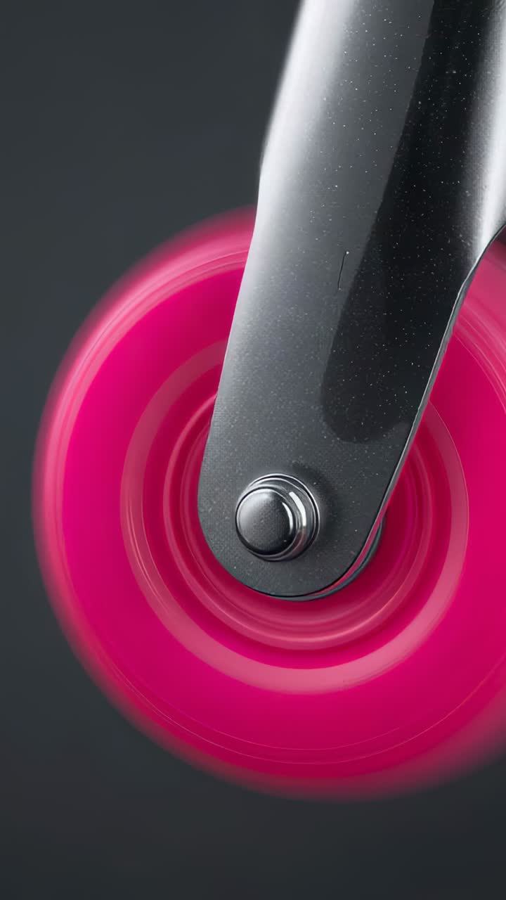 Video verticale: apertura con rotazione ravvicinata e macro di una rotella rosa, con forcella e bullone in metallo