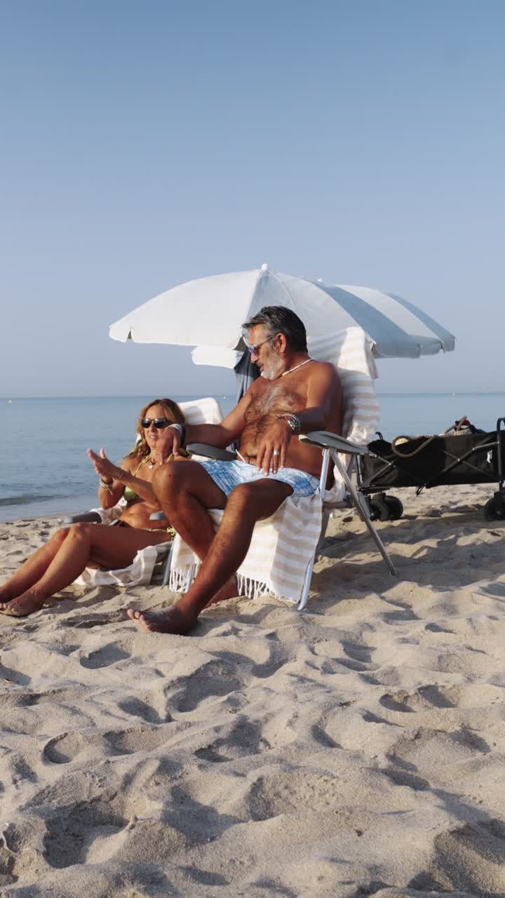 Couple relaxing on the beach under an umbrella