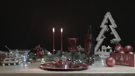 man takes a chocolate from a decorated christmas table in a dark room