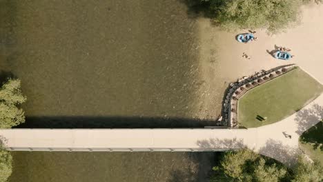 aerial shot straight down, flying upwards to reveal river floaters