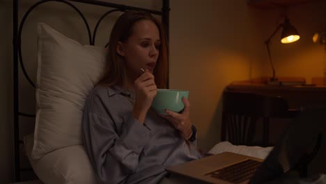 woman eating breakfast in bed