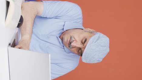 vertical video of the old man who fell asleep in front of a laptop.