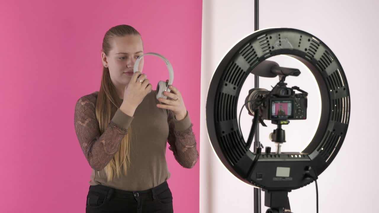 una adolescente grabando un vlog para su canal de estilo de vida hablando de auriculares