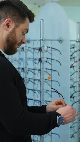 hombre probando gafas en una tienda óptica