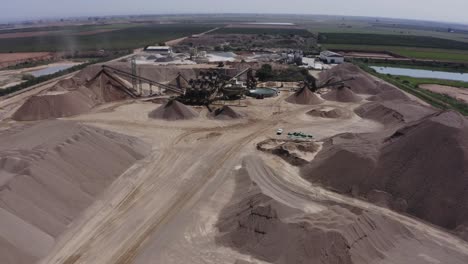 un gran camión cargado de arena se dirige hacia el sitio de construcción, fotos aéreas del camión junto con el sitio de construcción y los materiales