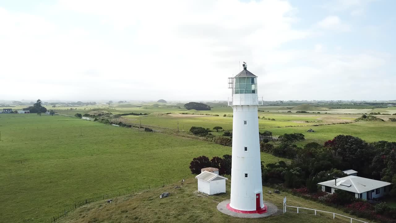 Aerial drone shot, Reveal Shot of the Cape Egmont Lighthouse in New Plymouth, Taranaki, New Zealand on a sunny day.