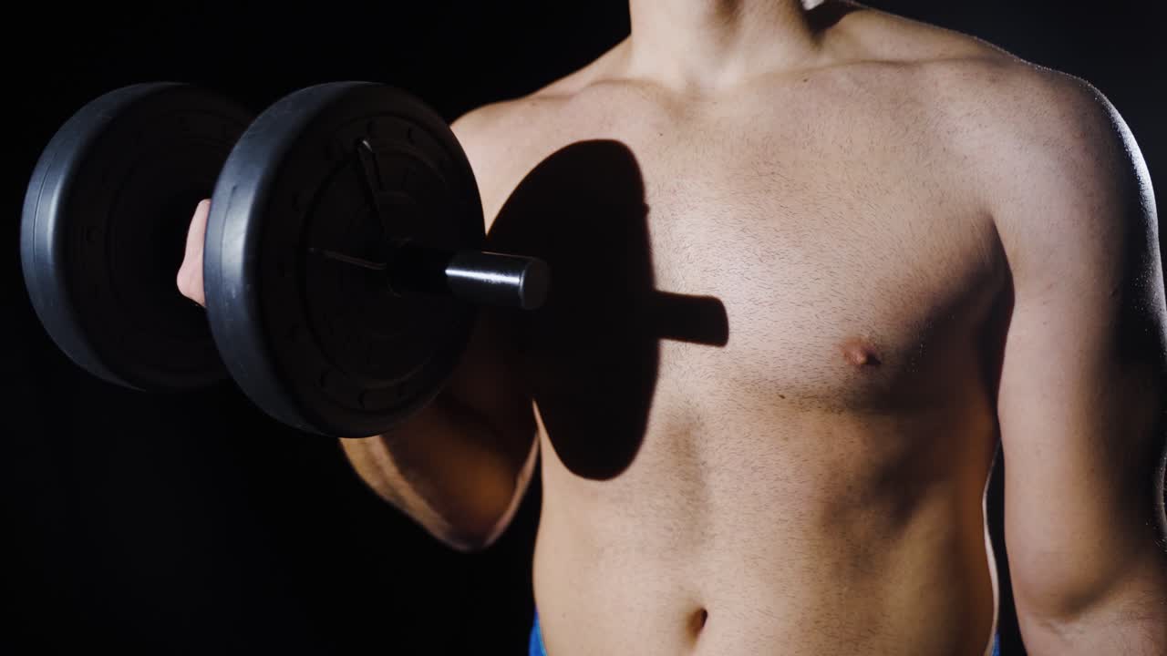 근육이 튼튼한 남자가 무게를 들어 올립니다.