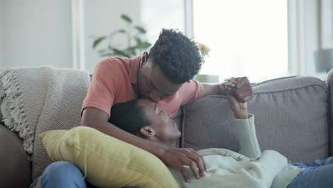 Love,-kiss-and-couple-on-a-sofa-holding-hands